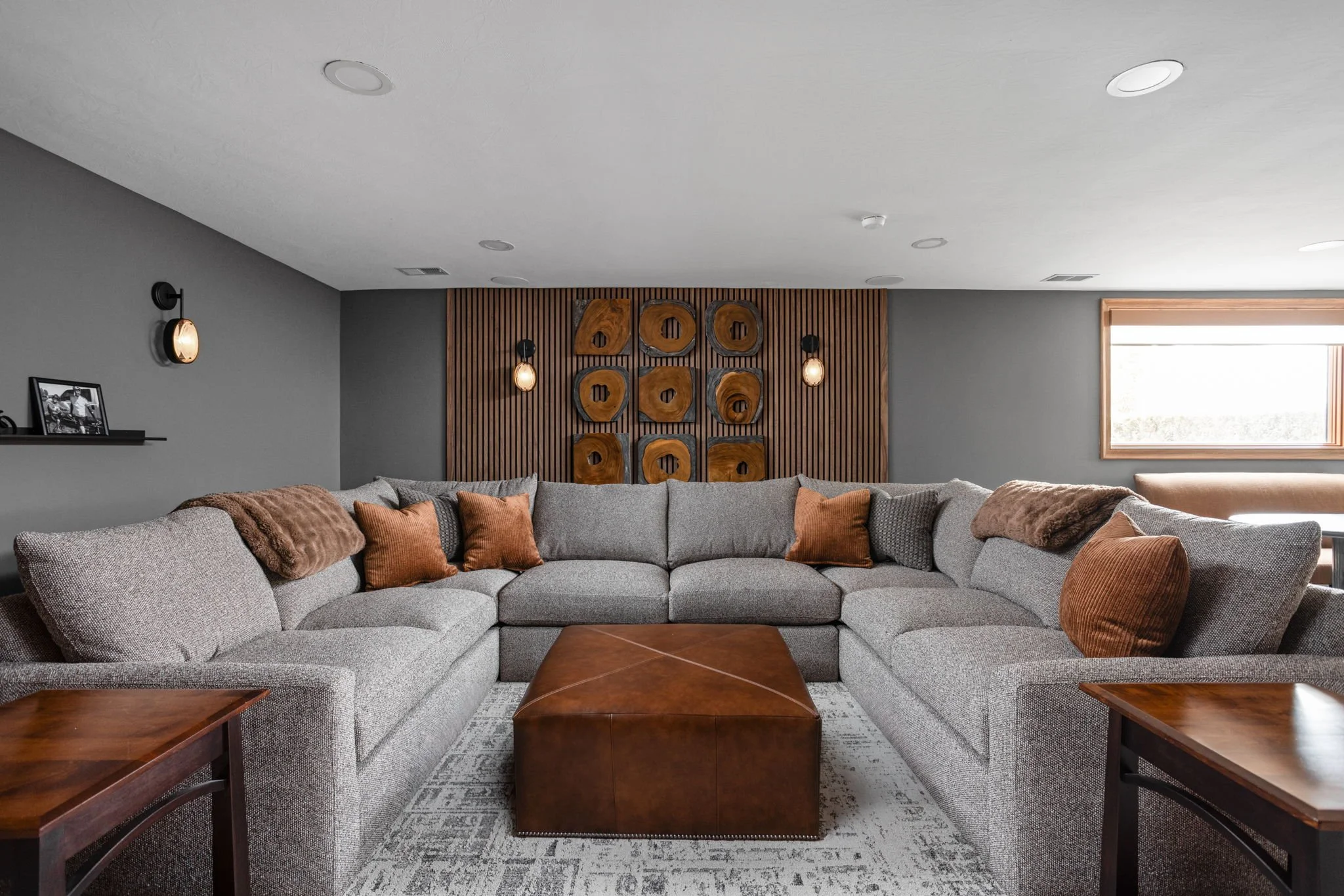Finished basement retreat with warm timber built-ins and tailored lounge seating
